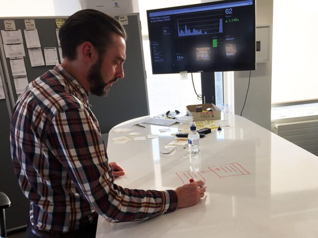 One of our designers, Tom Norman, sketches on a whiteboard desk.